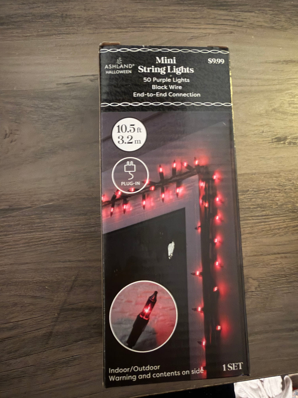 Packaging of mini string lights with red lights on a wooden surface