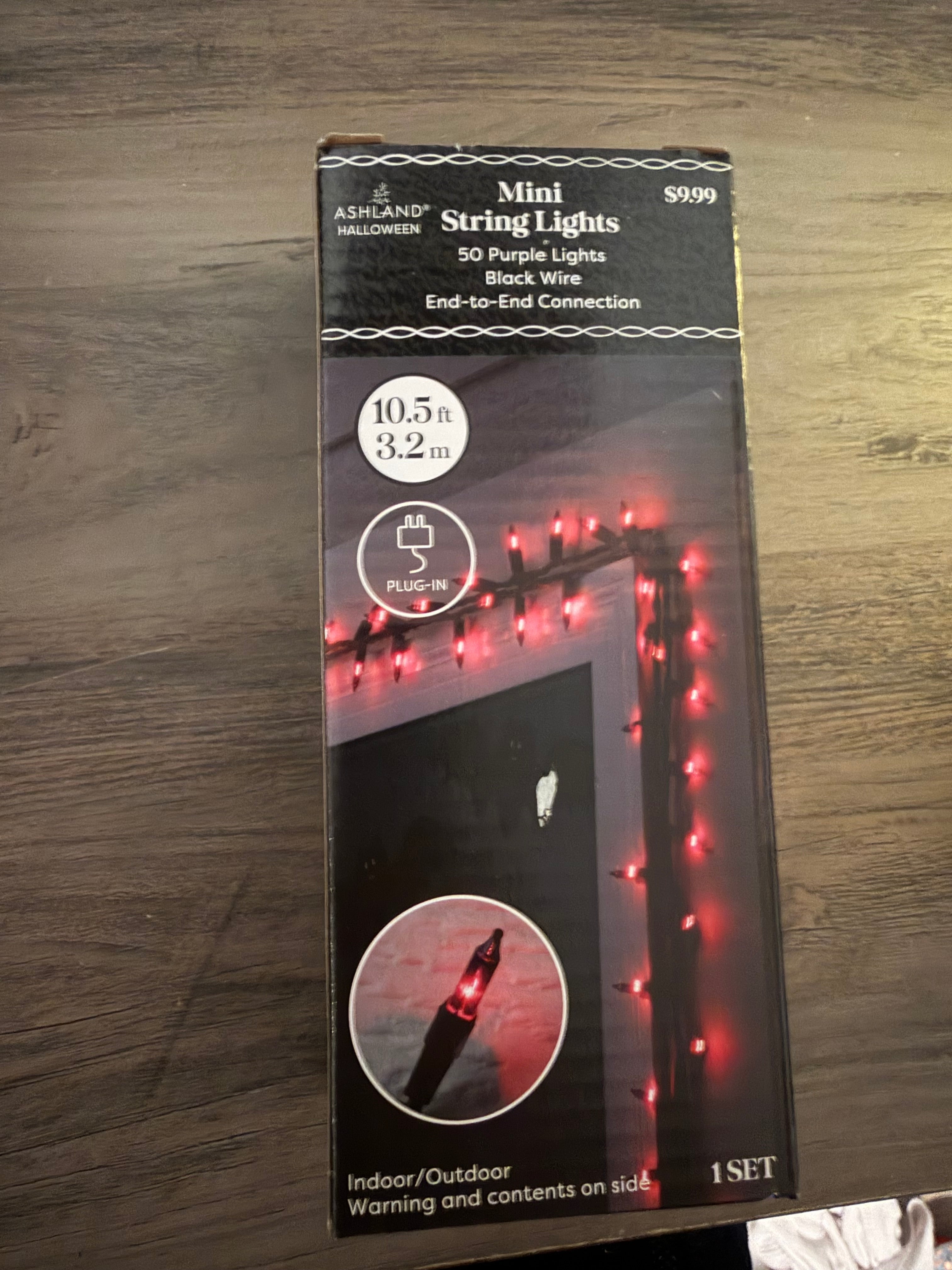 Packaging of mini string lights with red lights on a wooden surface