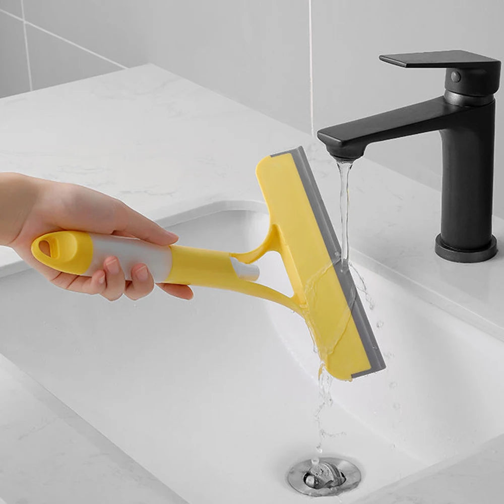 Person using a yellow squeegee to clean a bathroom window with water running down.